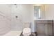 Elegant bathroom featuring a stand-up shower, white marble-look tiles, and contemporary vanity at 13627 Sw 103Rd Pl, Dunnellon, FL 34432