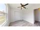 Bright bedroom featuring a ceiling fan, laminate flooring, and a view to the outside at 13627 Sw 103Rd Pl, Dunnellon, FL 34432