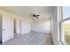 Bright bedroom with a ceiling fan and laminate flooring, featuring two doorways and a large window at 13627 Sw 103Rd Pl, Dunnellon, FL 34432