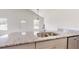 Kitchen island with stainless steel sink, granite countertop, and gray cabinets at 13627 Sw 103Rd Pl, Dunnellon, FL 34432