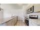 Bright kitchen featuring granite countertops, stainless steel appliances, and wood-look flooring at 13627 Sw 103Rd Pl, Dunnellon, FL 34432