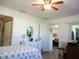 Well-lit bedroom with a ceiling fan, dresser, bed, and open doorway to another room at 13686 Sw 111Th Ave, Dunnellon, FL 34432