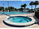 Community pool with a jacuzzi, lounge chairs, and lush landscaping is perfect for recreation and relaxation at 13686 Sw 111Th Ave, Dunnellon, FL 34432