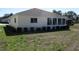 Back of a cozy home with a sunroom and neatly trimmed hedges in a tranquil backyard setting at 13686 Sw 111Th Ave, Dunnellon, FL 34432