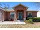 Inviting home featuring a covered entryway, decorative stone accents, and lush landscaping enhancing the curb appeal at 16272 Se 89Th Ct, Summerfield, FL 34491