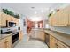 Well-lit kitchen features stainless steel appliances, tile flooring, and wooden cabinetry at 16272 Se 89Th Ct, Summerfield, FL 34491