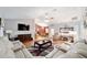 Open-concept living room with a large sectional, entertainment center, seamlessly connecting to the dining area at 16272 Se 89Th Ct, Summerfield, FL 34491