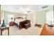 Bright main bedroom with large windows, ceiling fan, and carpeted floors at 16272 Se 89Th Ct, Summerfield, FL 34491