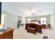Spacious main bedroom with large windows, ceiling fan, and carpeted floors at 16272 Se 89Th Ct, Summerfield, FL 34491