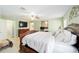 Spacious main bedroom with en suite bathroom, light green walls, and carpeted floors at 16272 Se 89Th Ct, Summerfield, FL 34491