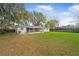 The backyard features a well maintained lawn and a white house with a screened patio at 1818 Se Lake Weir Ave, Ocala, FL 34471