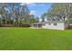 A spacious backyard with lush green grass and a white house at 1818 Se Lake Weir Ave, Ocala, FL 34471