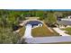 Exterior view of home with a long concrete driveway and manicured lawn surrounded by lush trees at 19 Juniper Pass, Ocala, FL 34480