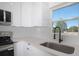 Modern kitchen with stainless steel appliances, white cabinets, stylish backsplash, and a view from the window at 19 Juniper Pass, Ocala, FL 34480