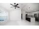 Bright living room featuring a ceiling fan and an open layout to the kitchen with stainless steel appliances at 19 Juniper Pass, Ocala, FL 34480