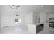 Spacious living room with vaulted ceilings, fan, and an open layout to a modern kitchen with a center island at 19 Juniper Pass, Ocala, FL 34480