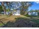 Grey home exterior with small porch entry, mature trees, and a separate garage at 221 Se 167Th Ct, Silver Springs, FL 34488