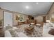 Open-concept living room featuring wood floors, light-colored walls, white furniture, and a stylish area rug at 221 Se 167Th Ct, Silver Springs, FL 34488