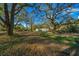 A vast yard with mature trees and a grey metal garage at the end of the property at 221 Se 167Th Ct, Silver Springs, FL 34488
