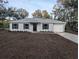 Charming single-story home with a gray exterior, black shutters and a well-maintained front yard at 261 Locust Pass Loop, Ocala, FL 34472
