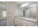 Bathroom with double sink vanity and doorway leading to carpeted bedroom at 29 Fisher Ter, Ocklawaha, FL 32179