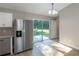 Open dining area with stainless steel refrigerator and sliding glass doors leading to a patio at 29 Fisher Ter, Ocklawaha, FL 32179