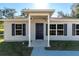 Close up of home's front door featuring a covered entry and attractive black shutters at 29 Fisher Ter, Ocklawaha, FL 32179