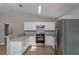 Spacious kitchen showcasing stainless steel appliances, light countertops and wood flooring at 29 Fisher Ter, Ocklawaha, FL 32179