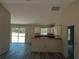Open concept living room with gray floors, white cabinets and sliding glass doors that bring in natural light at 29 Fisher Ter, Ocklawaha, FL 32179