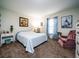 Well-lit bedroom with a cozy armchair and stylish blue and white curtains at 4941 Nw 32 Street, Ocala, FL 34482