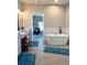 Bright bathroom featuring a modern soaking tub with gray cabinets and wood-look floor tiles at 5124 Cr 634S, Bushnell, FL 33513