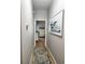 Neutral hallway featuring luxury vinyl plank flooring and a dolphin picture at 5124 Cr 634S, Bushnell, FL 33513