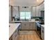 Modern kitchen with gray cabinets, stainless steel appliances, and stylish backsplash at 5124 Cr 634S, Bushnell, FL 33513