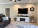 Cozy living room featuring a fireplace, large television, comfortable seating and wood-look floors at 5124 Cr 634S, Bushnell, FL 33513