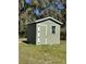Green storage shed with white trim set in grassy lawn, providing ample outdoor storage at 5124 Cr 634S, Bushnell, FL 33513