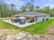 Backyard view with a patio with a hot tub, pergola, and outdoor dining, all surrounded by lush greenery at 5620 Sw 172Nd Loop, Ocala, FL 34473