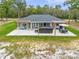 Aerial view of backyard featuring a spacious patio with a hot tub, pergola, outdoor dining area, and ample green space at 5620 Sw 172Nd Loop, Ocala, FL 34473