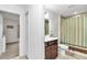 Cozy bathroom with a shower/tub combo, brown vanity, mirror, and a peek into the adjacent bedroom at 5620 Sw 172Nd Loop, Ocala, FL 34473