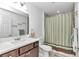 Neutral bathroom features a shower/tub combo, large mirror, vanity, and neutral decor at 5620 Sw 172Nd Loop, Ocala, FL 34473