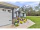 Stylish home exterior featuring a two-car garage and a landscaped front yard with decorative rock features at 5620 Sw 172Nd Loop, Ocala, FL 34473