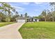 Beautiful single-story home featuring a manicured lawn and a long driveway leading to a two-car garage at 5620 Sw 172Nd Loop, Ocala, FL 34473