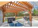 View of a pergola with lights, grill, table and seating providing an ideal outdoor dining and entertainment space at 5620 Sw 172Nd Loop, Ocala, FL 34473