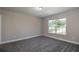 Bedroom features a large window for natural light, neutral paint, and new carpet at 59 Fisher Ct, Ocklawaha, FL 32179
