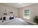 Cozy bedroom with a comfortable bed, window overlooking the backyard, neutral paint, and a matching nightstand at 59 Fisher Ct, Ocklawaha, FL 32179