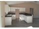 Bright kitchen featuring white cabinets, black countertops, and wood grain flooring at 59 Fisher Ct, Ocklawaha, FL 32179