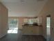 Open living room featuring sliding glass doors, white cabinets, and wood grain flooring at 59 Fisher Ct, Ocklawaha, FL 32179