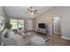 Bright living room with vaulted ceiling, ceiling fan, large window, neutral tones, and an inviting seating arrangement at 59 Fisher Ct, Ocklawaha, FL 32179