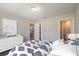 Bright main bedroom featuring a comfortable bed, dresser, a view to the kitchen and bathroom, and soft, neutral decor at 59 Fisher Ct, Ocklawaha, FL 32179