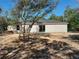 Backyard view of a one-story home featuring a sliding glass door and fresh landscaping at 59 Fisher Ct, Ocklawaha, FL 32179