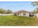 A spacious backyard presents a serene outdoor space, complete with a covered patio area for relaxation and entertainment at 8330 Se 161St St, Summerfield, FL 34491